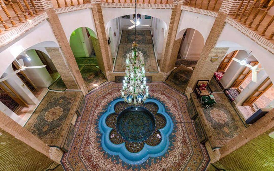 تصویر طبقه همکف خانه ای تاریخی با حوضی در وسط آن
