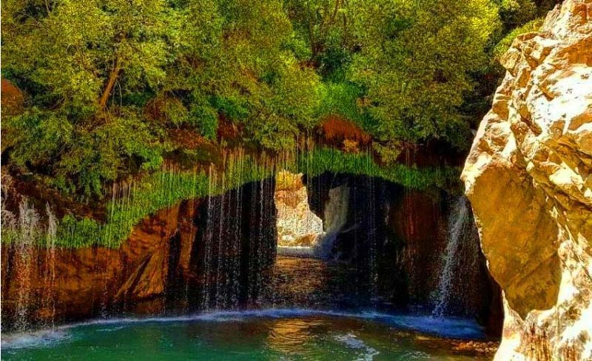 آبشار آب ملخ بر صخره های خز گرفته از نمای نزدیک