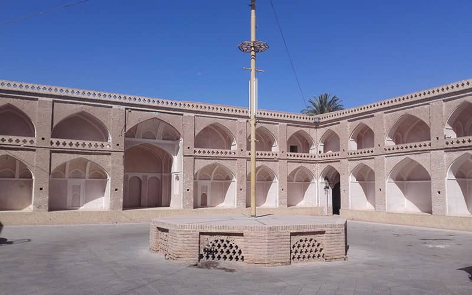 حسینیه بزرگی با دیوارهای طاق نما و سکوی آجری