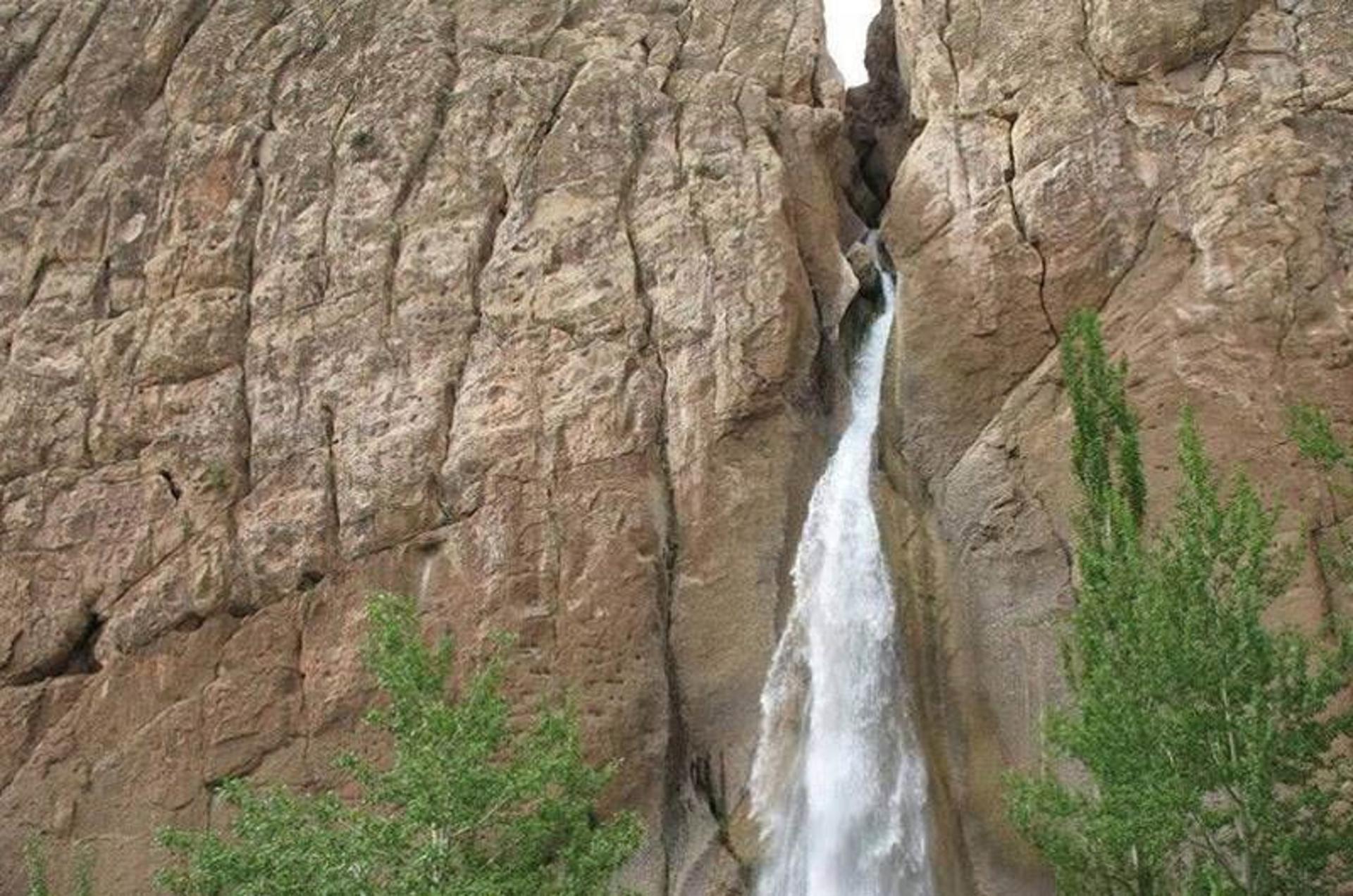 آبشار سمیرم میان صخره های کوهستانی از نمای دور