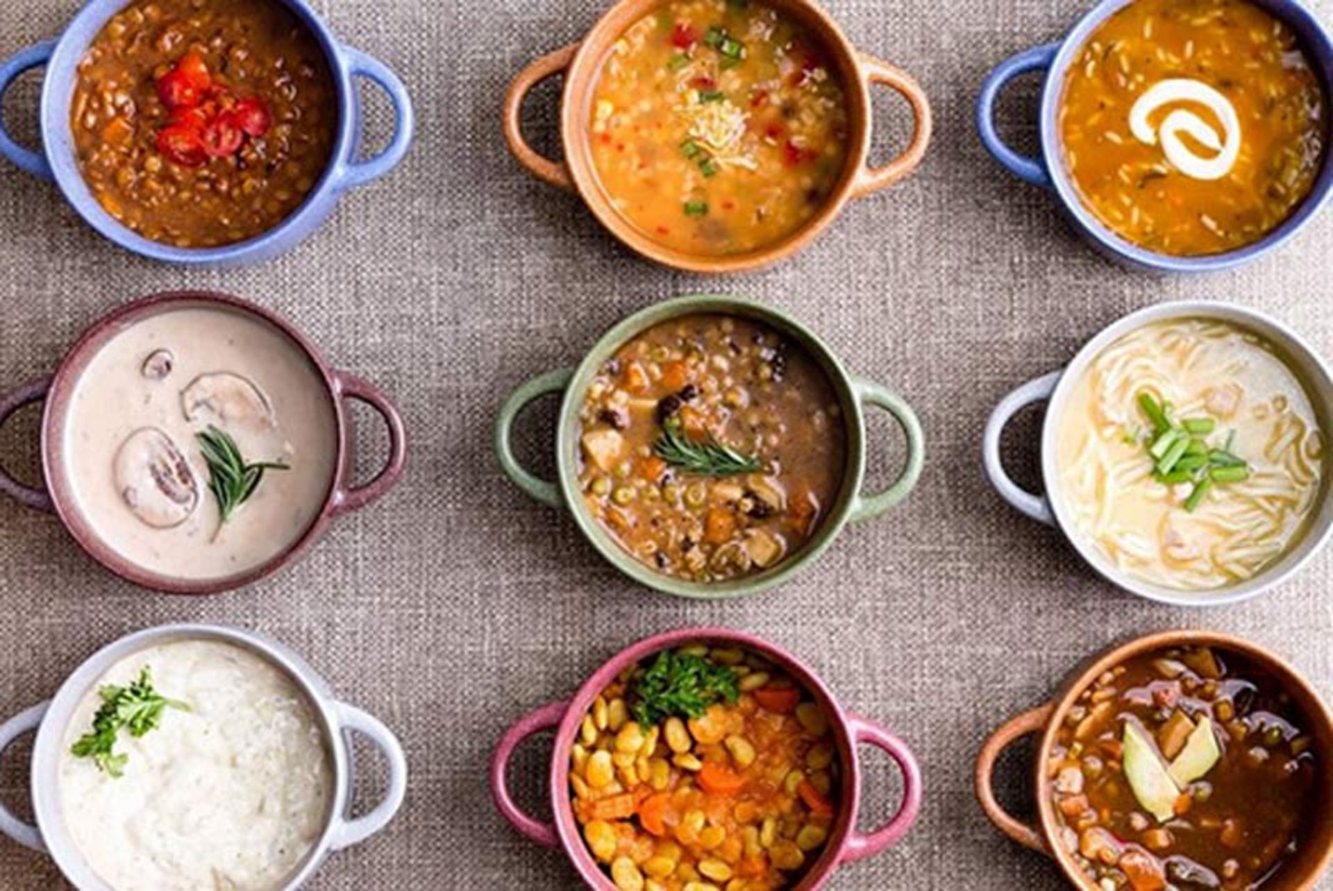انواع سوپ در ظروف رنگی از نمای بالا