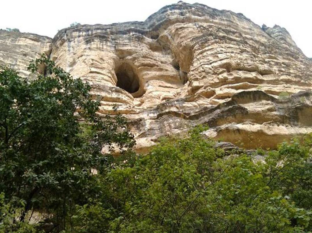 دهانه ورودی غار میرملاس لرستان از نمای دور در دامنه کوه