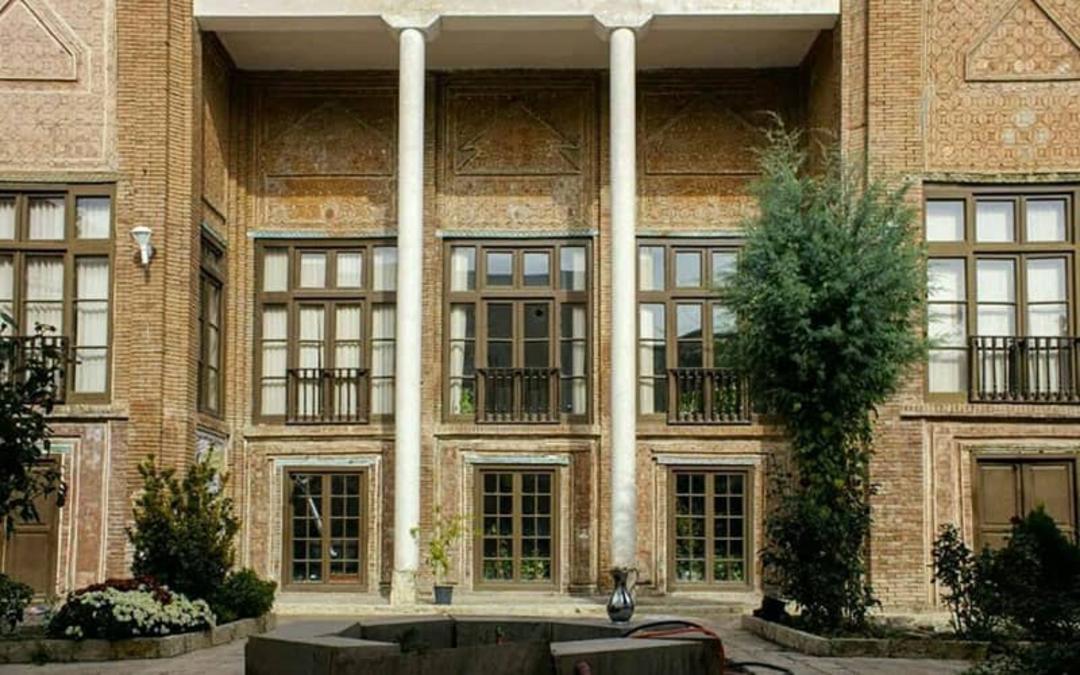 خانه ای قدیمی با دو ستون بلند سفید و چندین پنجره