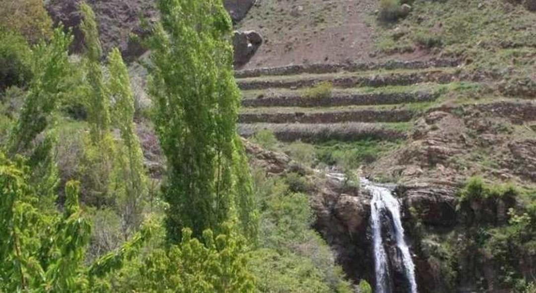 جریان آبشاری کم‌آب در منطقه‌ای سرسبز