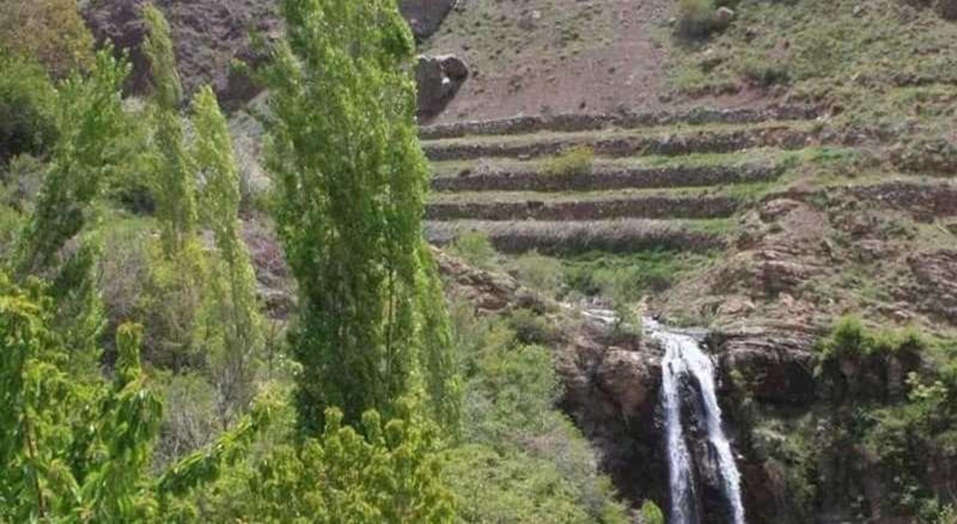 جریان آبشاری کم‌آب در منطقه‌ای سرسبز