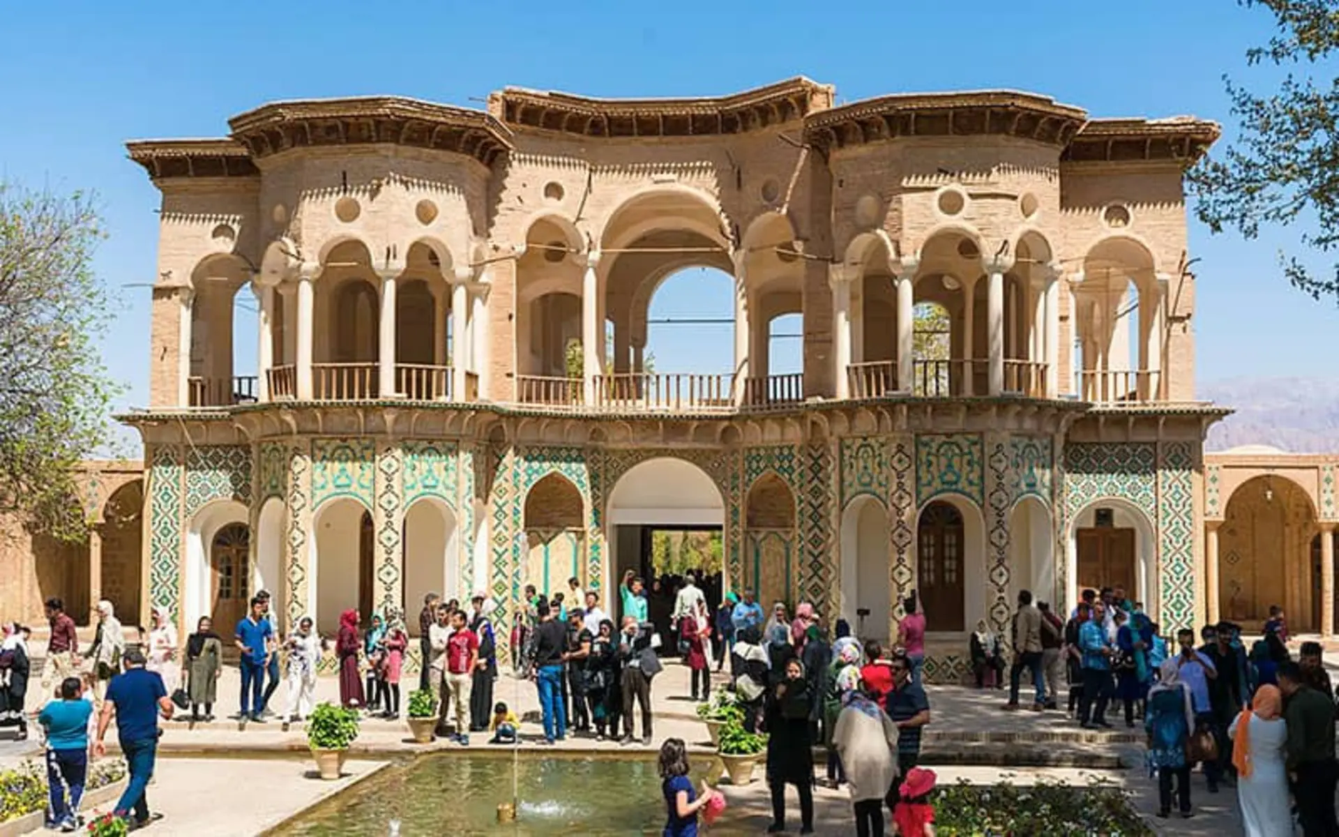 حضور گردشگران در مقابل عمارتی تاریخی و دو طبقه
