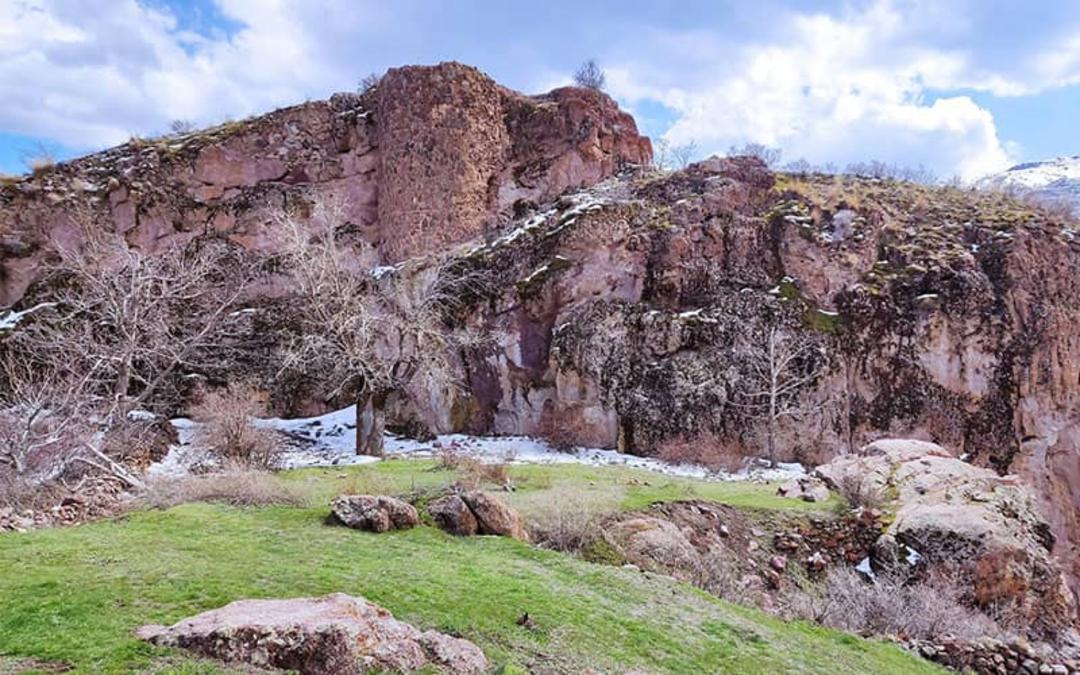 قلعه ای سنگی بر فراز کوهی سرسبز
