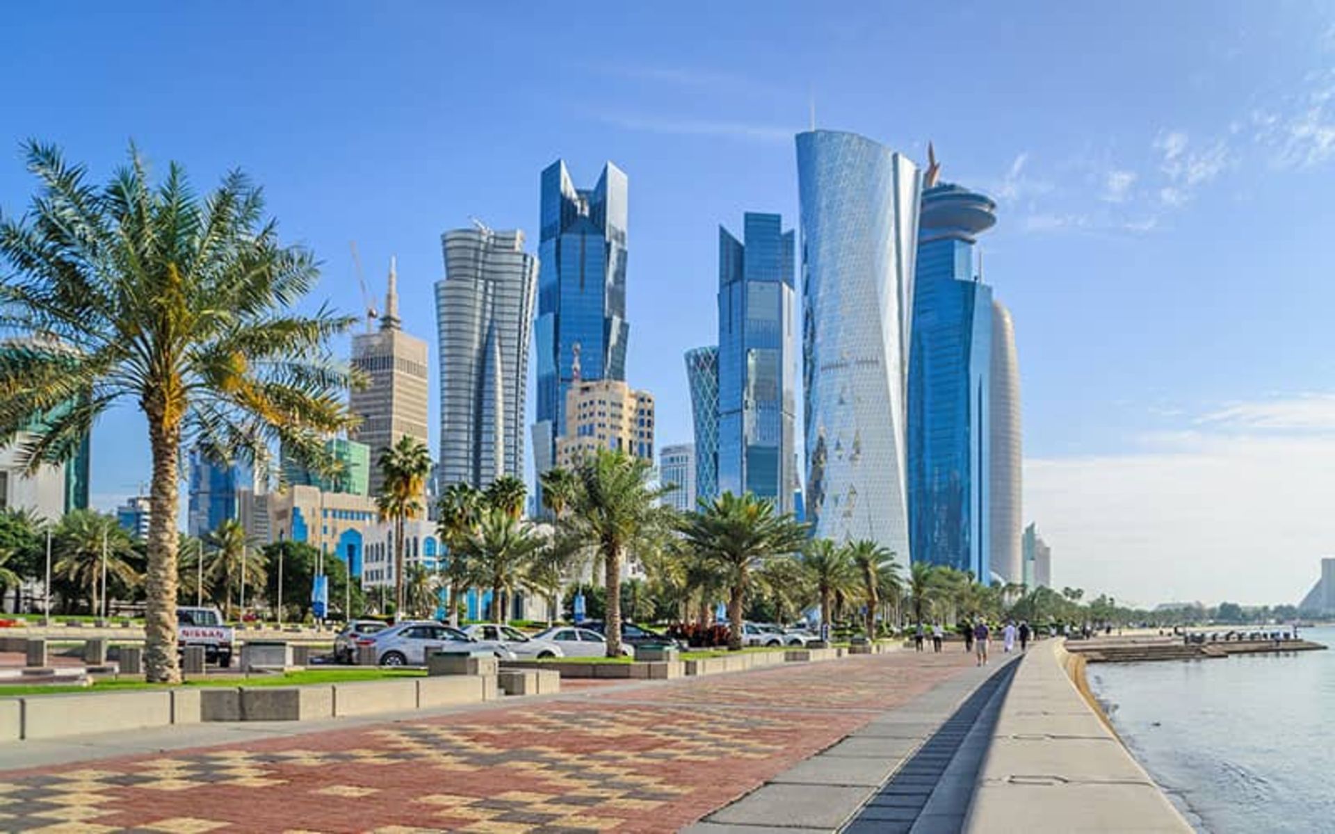 مسیر پیاده‌روی کنار دریا با آسمان‌خراشی در انتهای مسیر