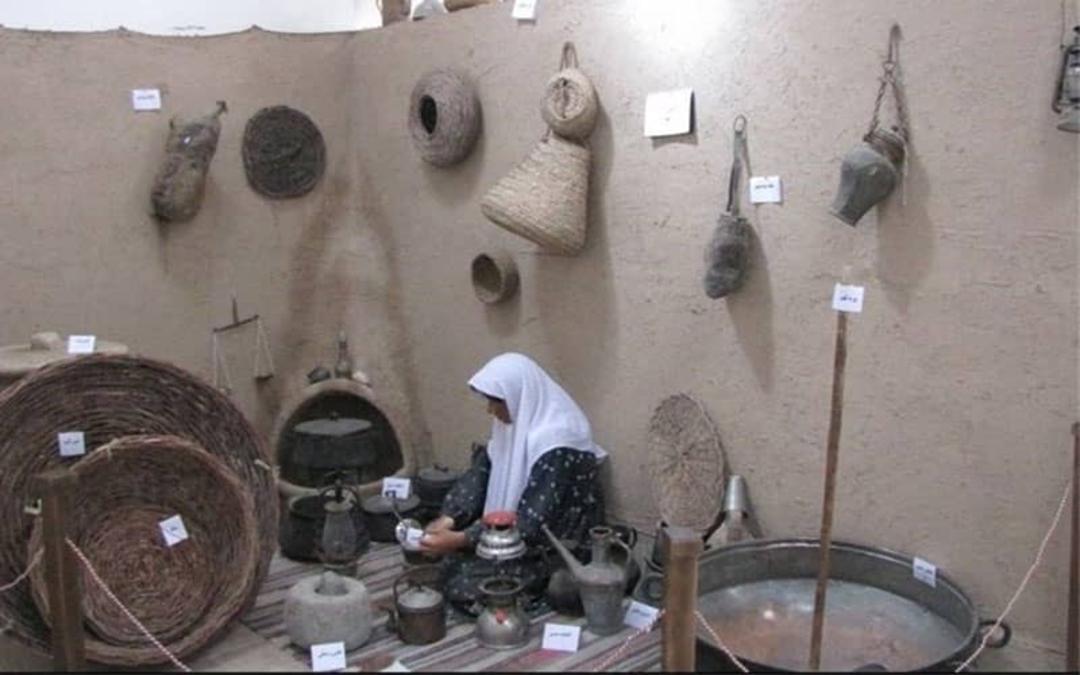 مجسمه زنی در کنار وسایل زندگی روستایی