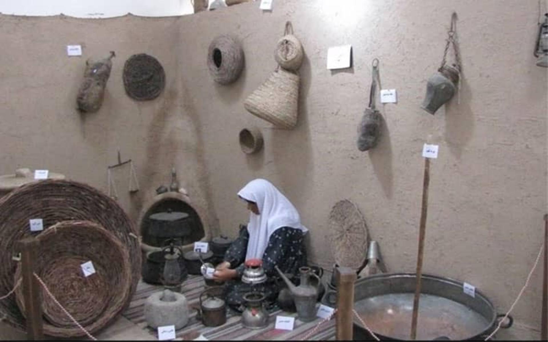 مجسمه زنی در کنار وسایل زندگی روستایی