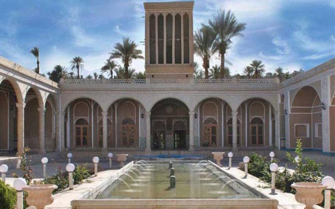 عمارتی یک طبقه با بادگیر و حوض و درختان نخل