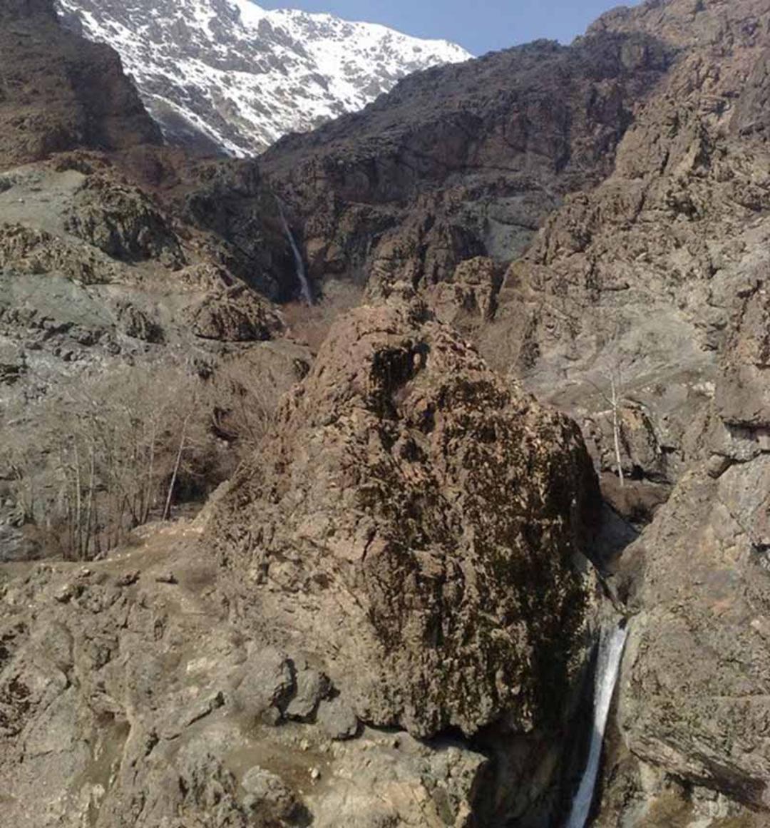 آبشار اوسون میان کوهستان های بلند و پر برف از نمای دور