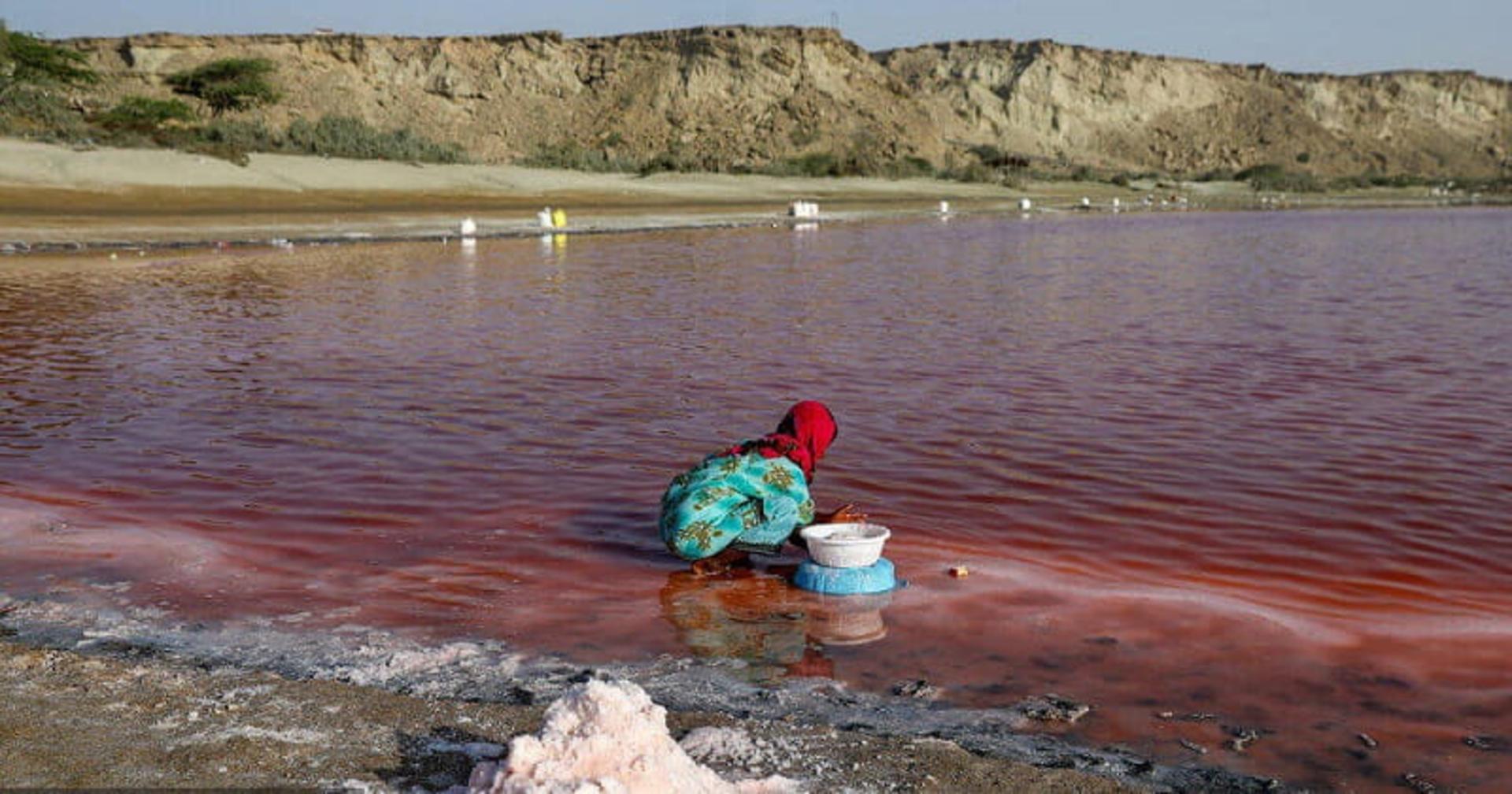 دختر بچه ای در حال جمع آوری نمک از تالاب لیپار