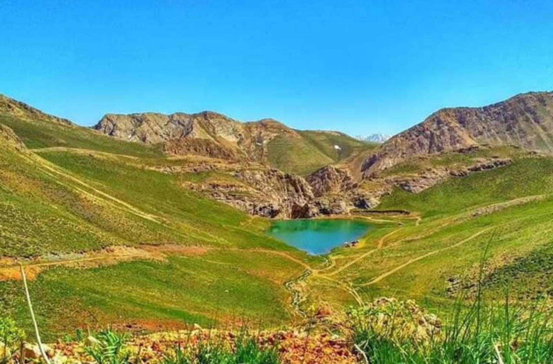 دریاچه لزور میان مراتع سبز و کوهستان از نمای بالا