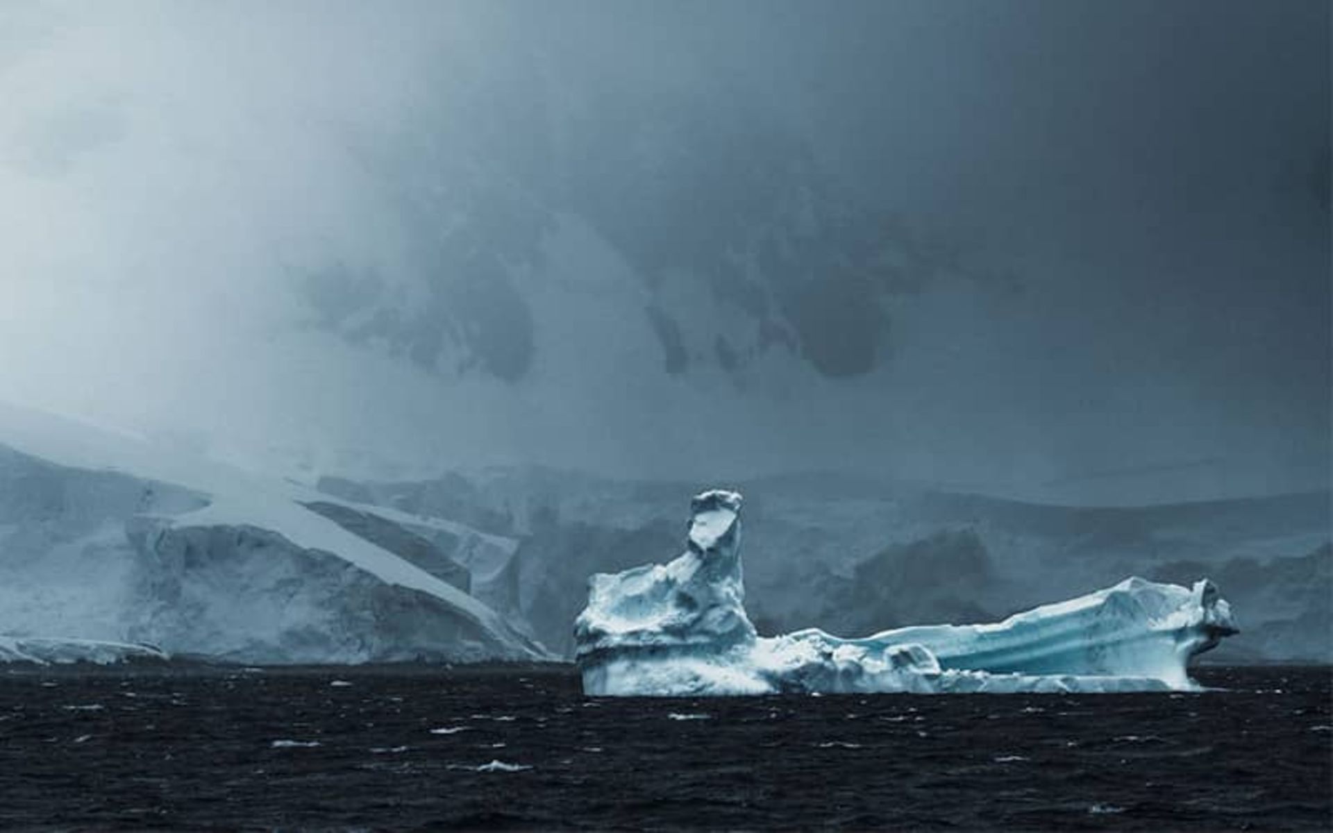 هوای ابری و رنگ تیره دریا و صخره ها