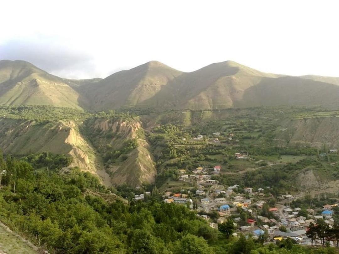 چشم انداز روستای نیاک در دامنه کوهستان سرسبز