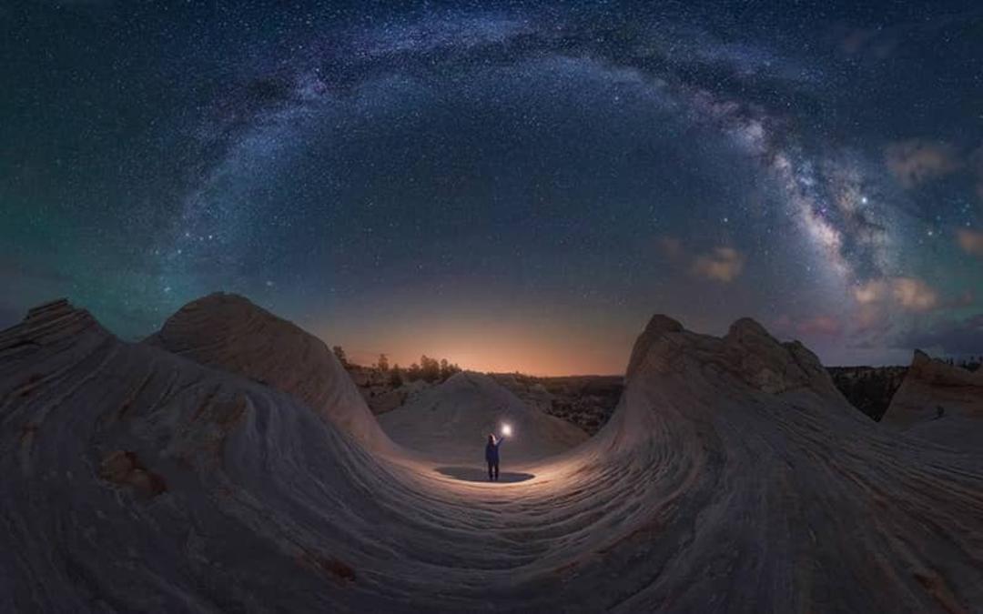 مسیری مدور و پرستاره بالای سر مردی در میان کوه ها