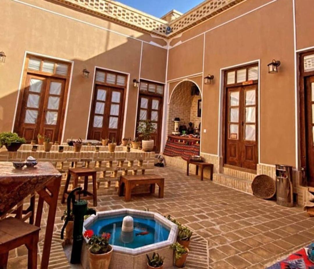 حیاط هاستل واحه یزد با حوض فیروزه ای و پنج دری