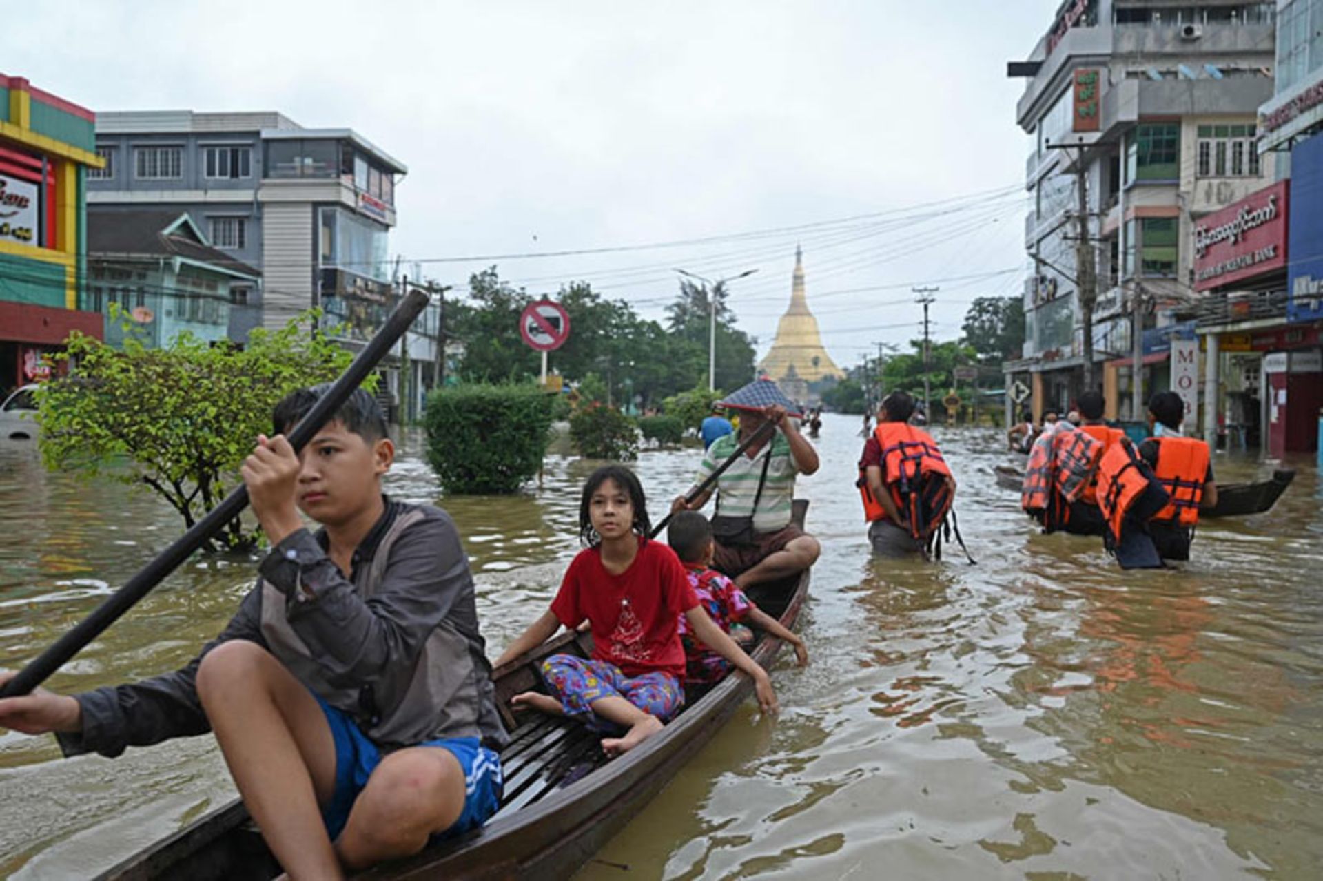 عبور مردم میانمار از خیابان‌های سیل زده؛ منبع عکس: Getty Images؛ عکاس: Sai Aung Main