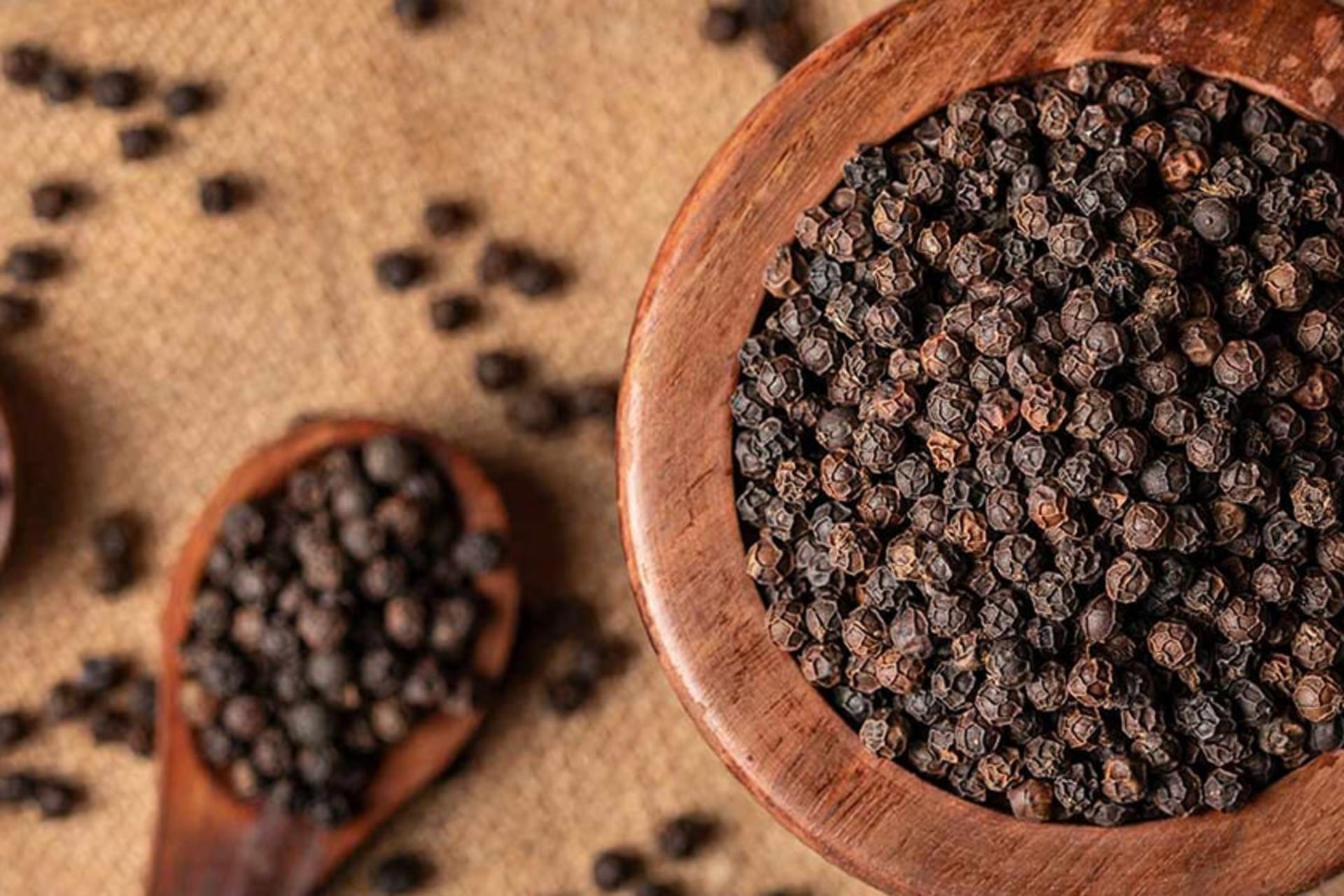 یک ظرف چوبی پر از فلفل سیاه