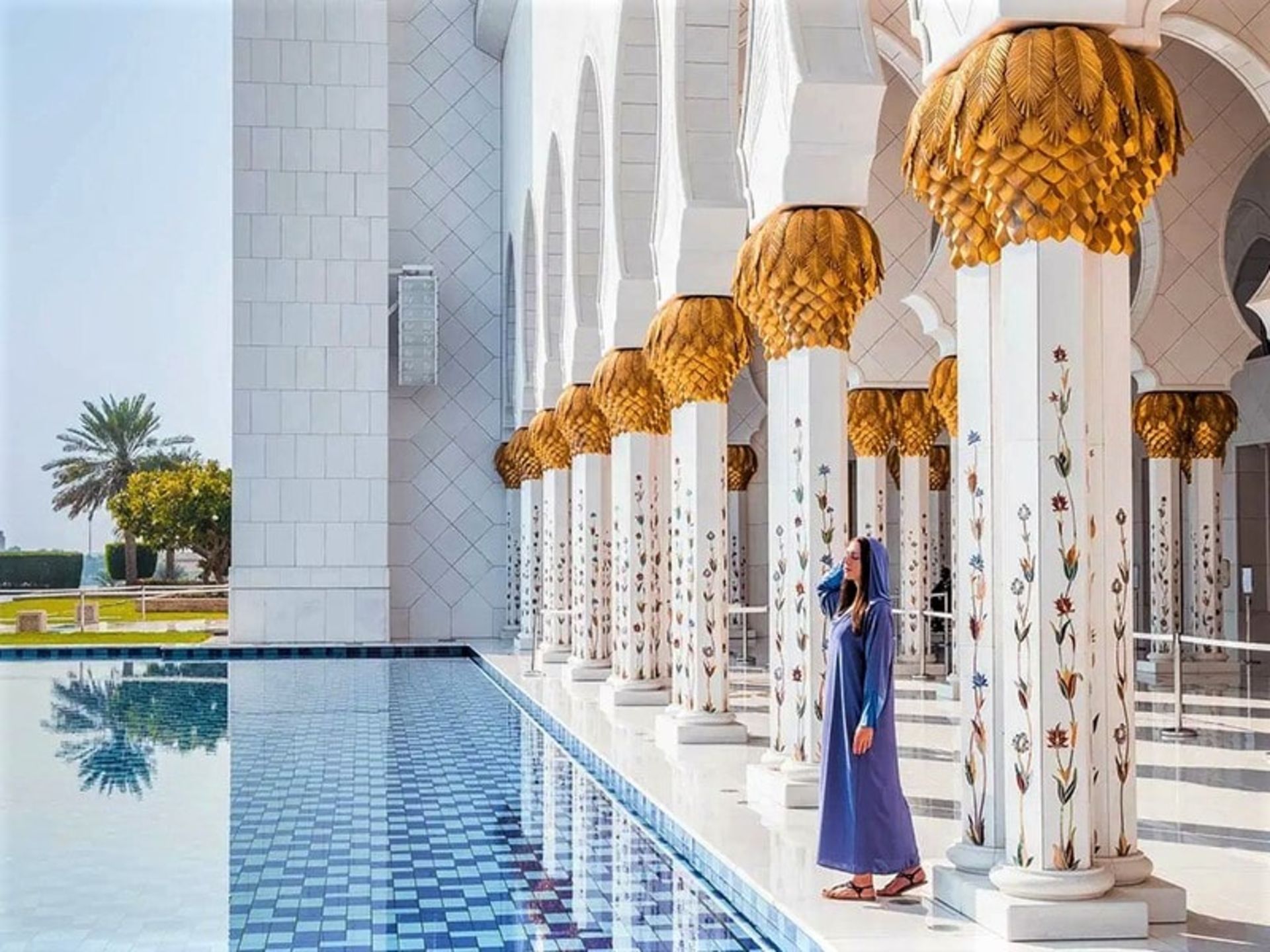 گردشگر زن در کنار استخر انعکاسی مسجد شیخ زاید، منبع عکس: shewandersabroad.com، عکاس: ناشناس