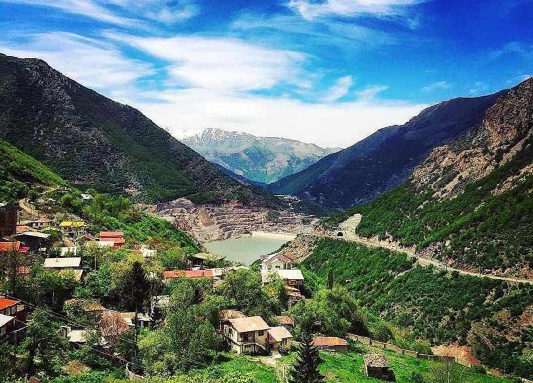روستای کوهستانی سیاه بیشه زیر آسمان آبی از نمای دور، منبع عکس: صفحه اینستاگرام bama_gardesh، عکاس نامشخص