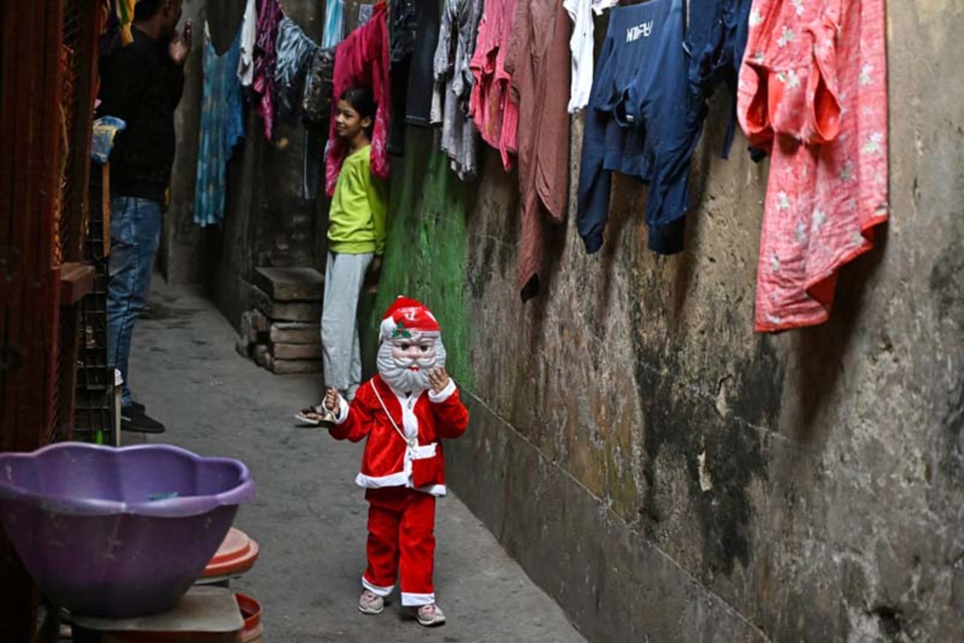 کودکی با لباس بابا نوئل در خیابانی در کلکته هند؛ منبع: Getty Images، عکاس: Dibyangshu Sarkar
