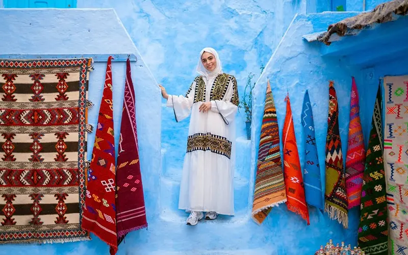 زن گردشگر در کنار صنایع دستی شهر شفشاون مراکش، منبع عکس: flytographer.com، عکاس: نامشخص
