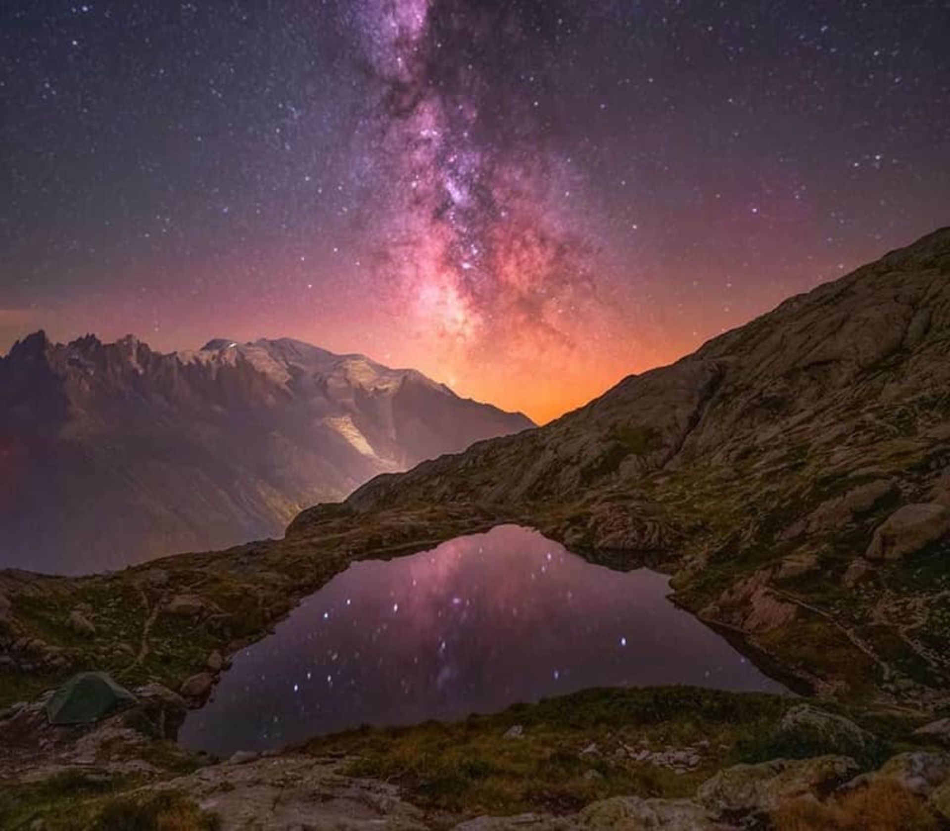 آسمان رنگارنگ شب در پس صخره ای سنگی