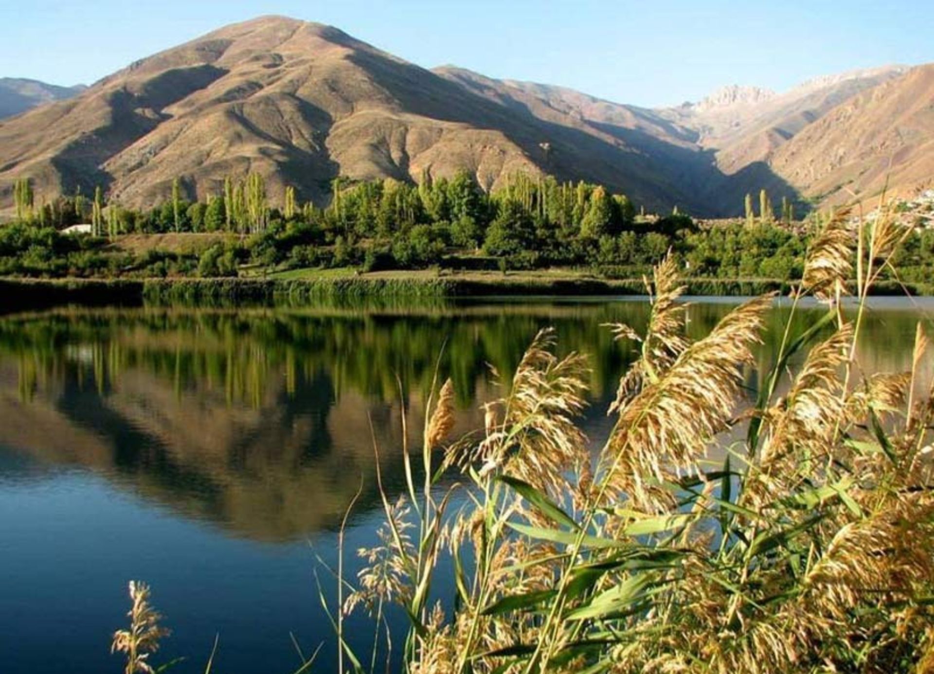دریاچه اوان در جوار کوهستان و درختان سبز