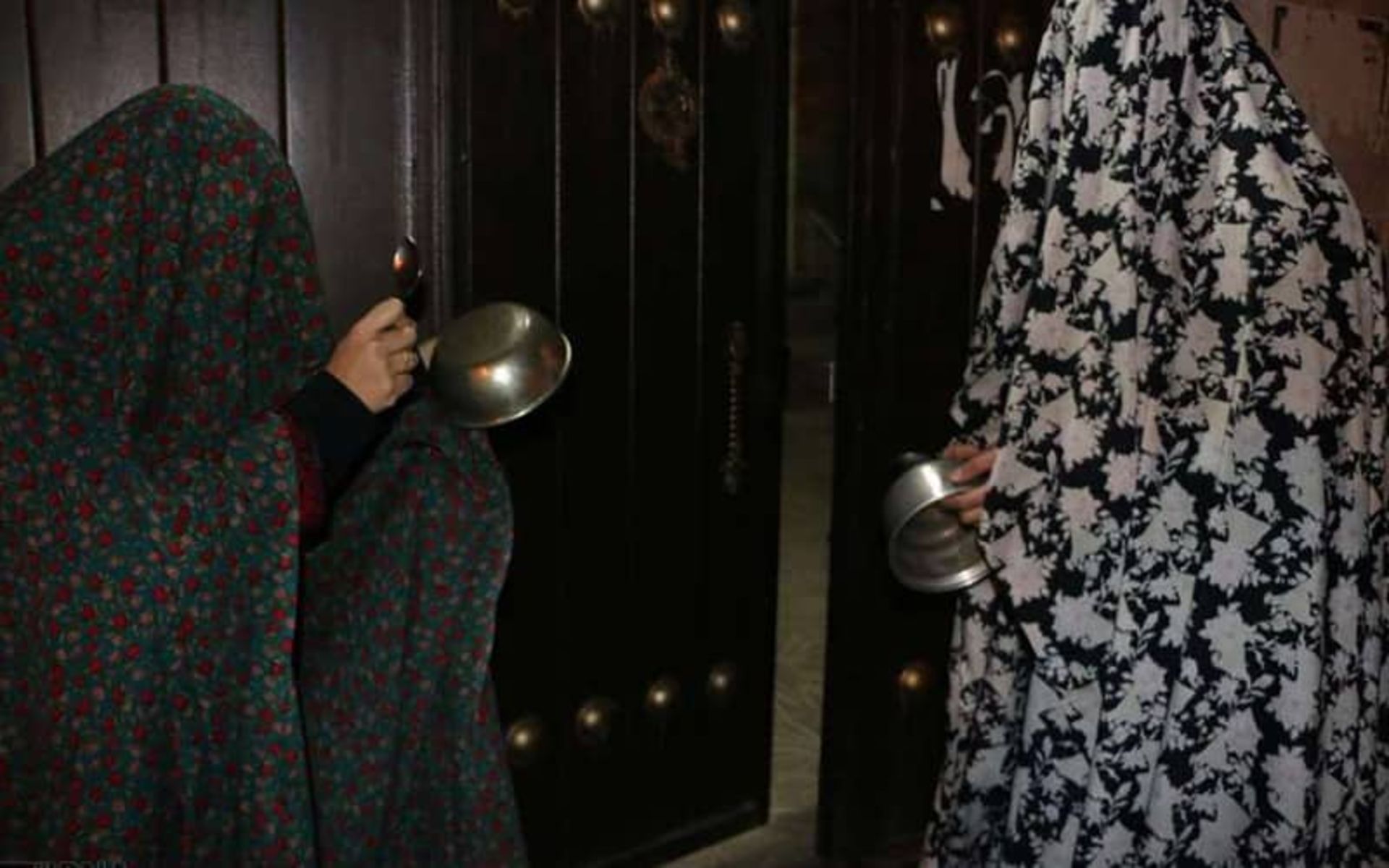 دو نفر با چادر رنگی در قاشق زنی چهارشنبه سوری