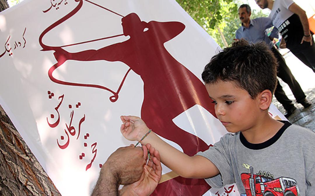 بستن دست بند روی دست پسربچه در تیرگان 