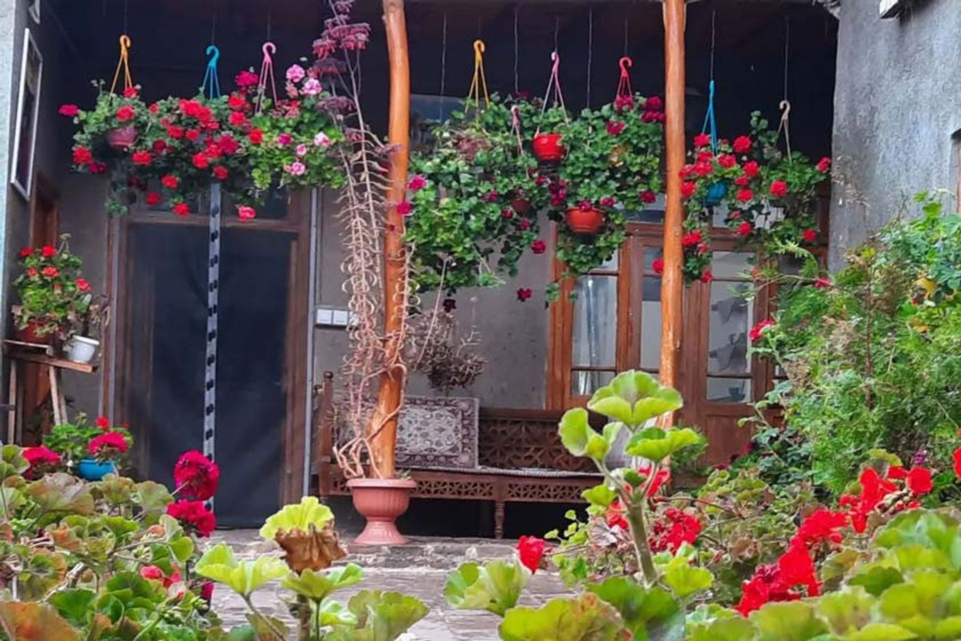 نمای بیرونی اقامتگاه بومگردی عمارت سلیمان با گلدان های رنگی و گلکاری های زیبا