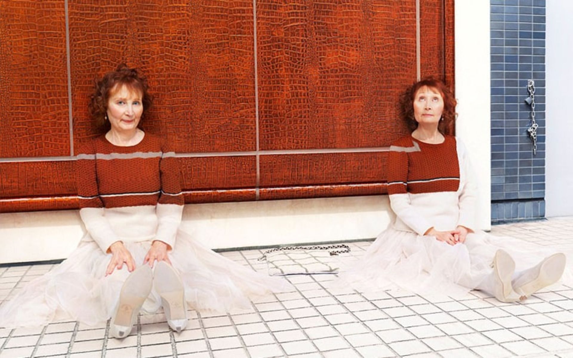 دو زن با لباس بافتنی قرمز در کنار دیوار قرمز