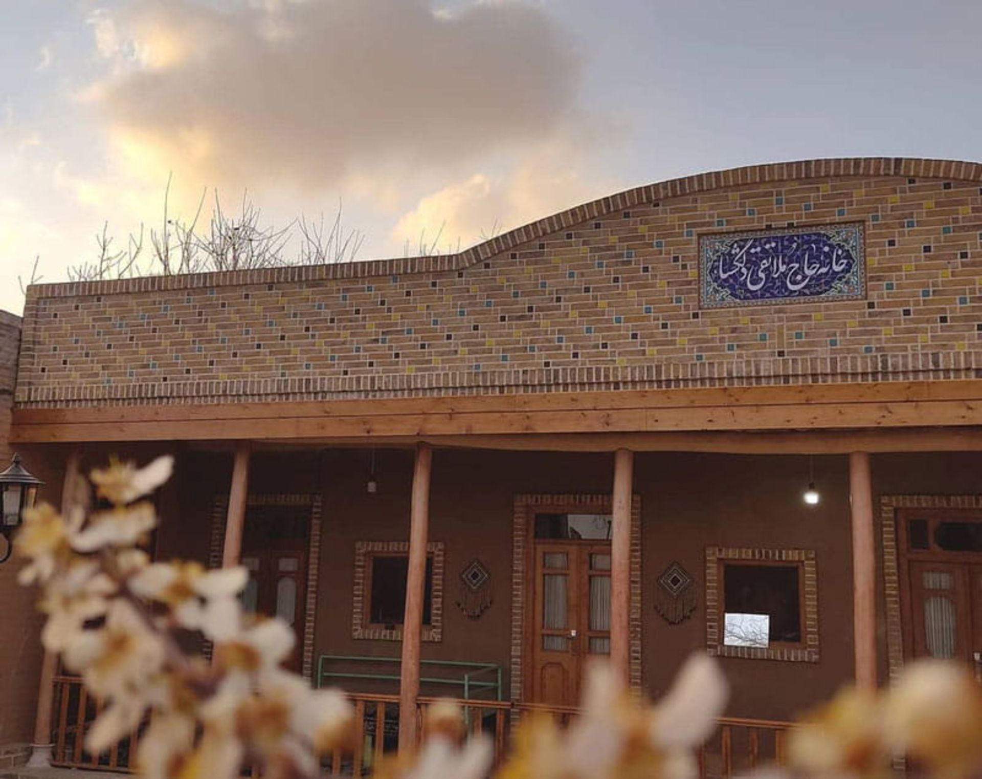 سردر ورودی اقامتگاه بومگردی سرای دلگشا از نمای شکوفه های بهاری
