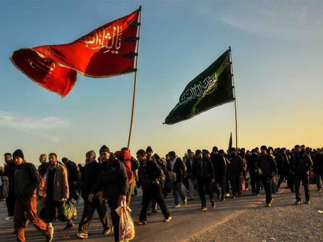 زائران با بیرق امام حسین در پیاده روی اربعین
