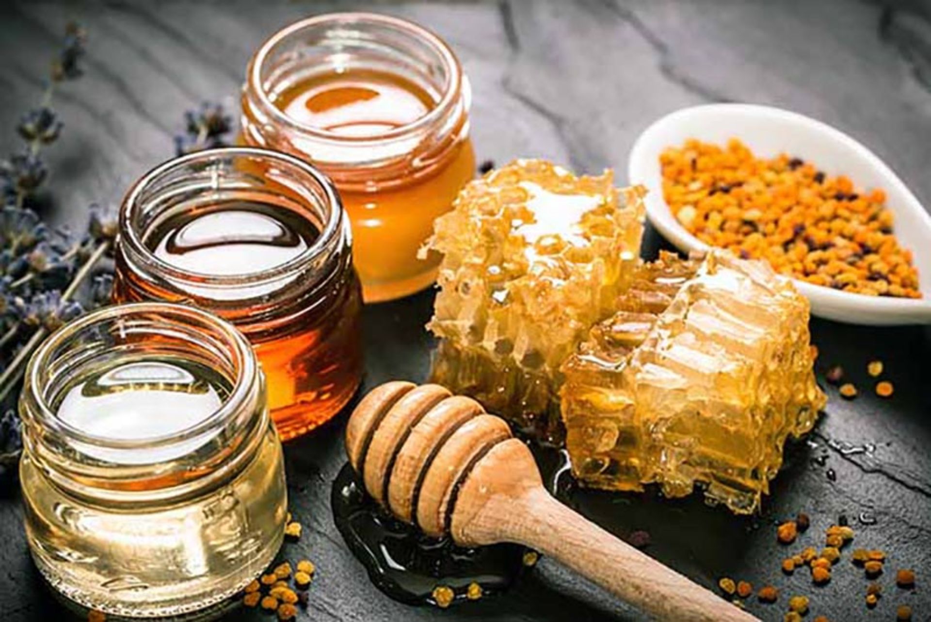 انواع تیره و روشن عسل در کنار موم؛ منبع عکس: kandrafoods؛ عکاس: نامشخص 