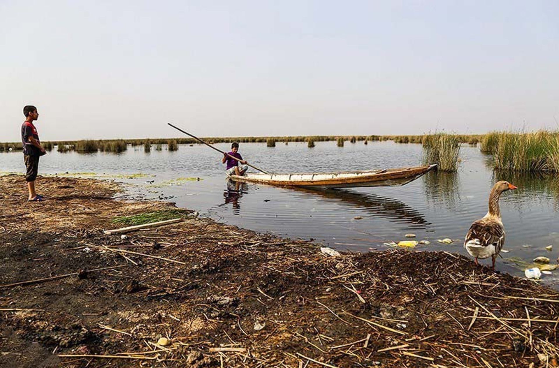 دو پسر بچه اهل سراخیه در کنار آب و قایق؛ منبع عکس: tasnim news؛ عکاس: مهدی پدرام خو