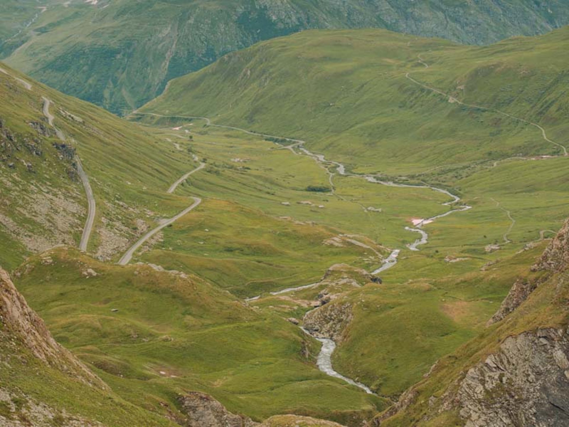 دشت و تپه‌ای سر سبز در میان کوهستان 