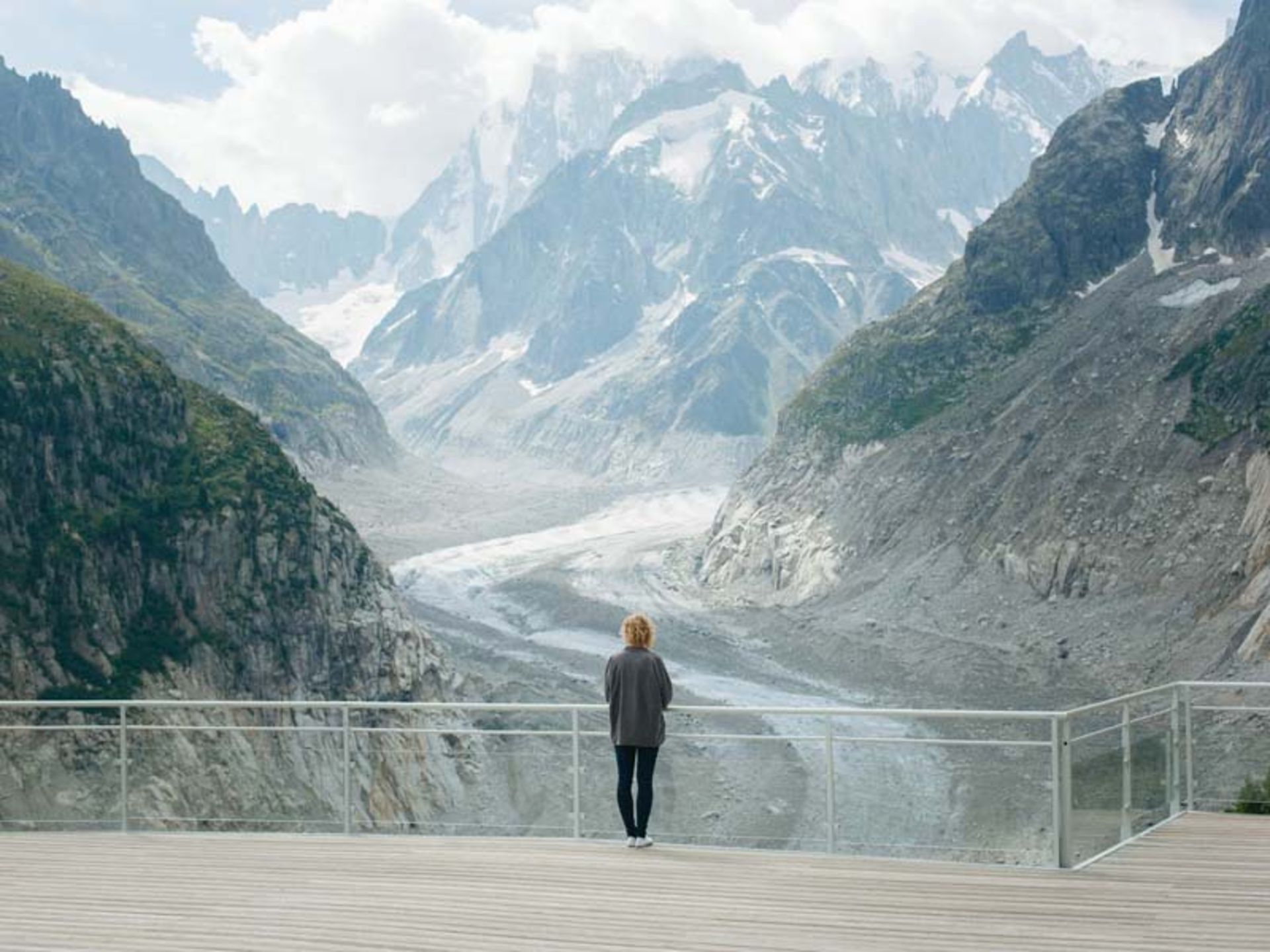 فردی در حال تماشای کوهستان و جاده برفی