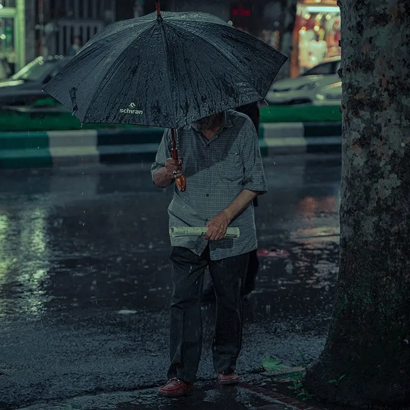 مردی زیر باران در شهر رشت