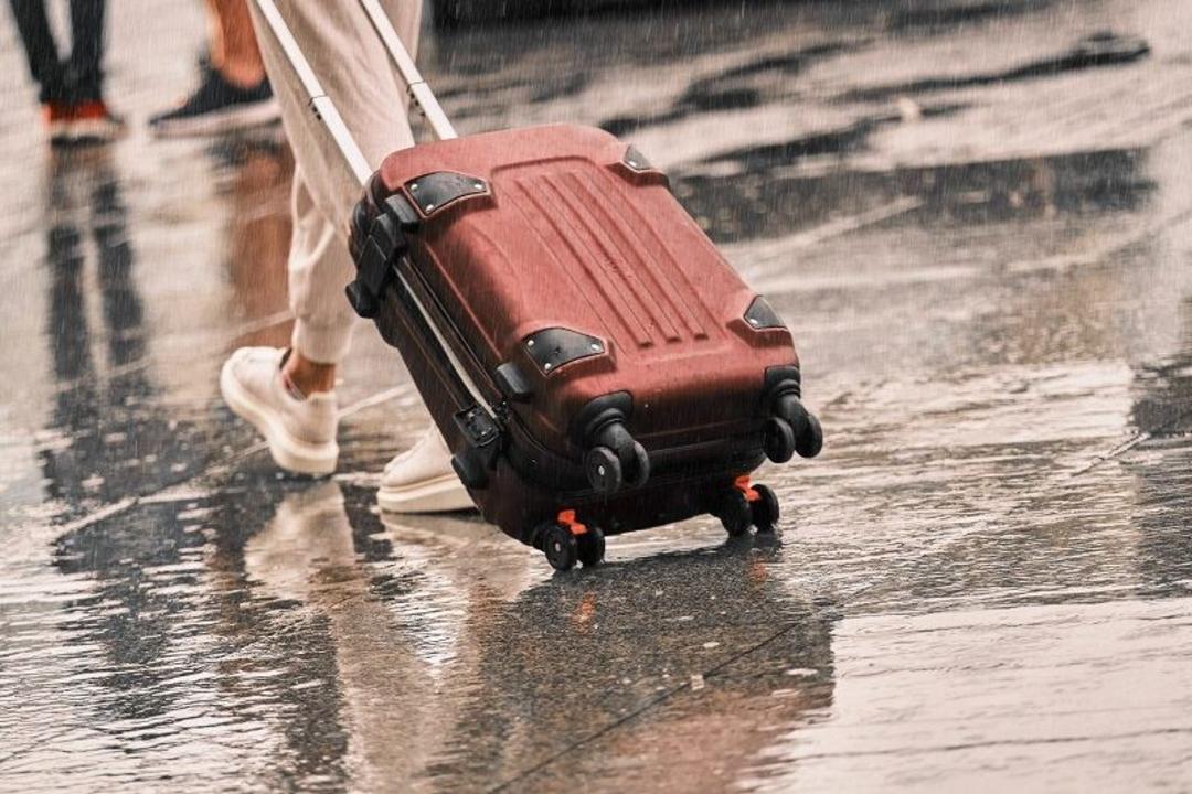 گردش با چمدان در هوای بارانی؛ منبع عکس: وب سایت Explore.com. عکاس: نامشخص
