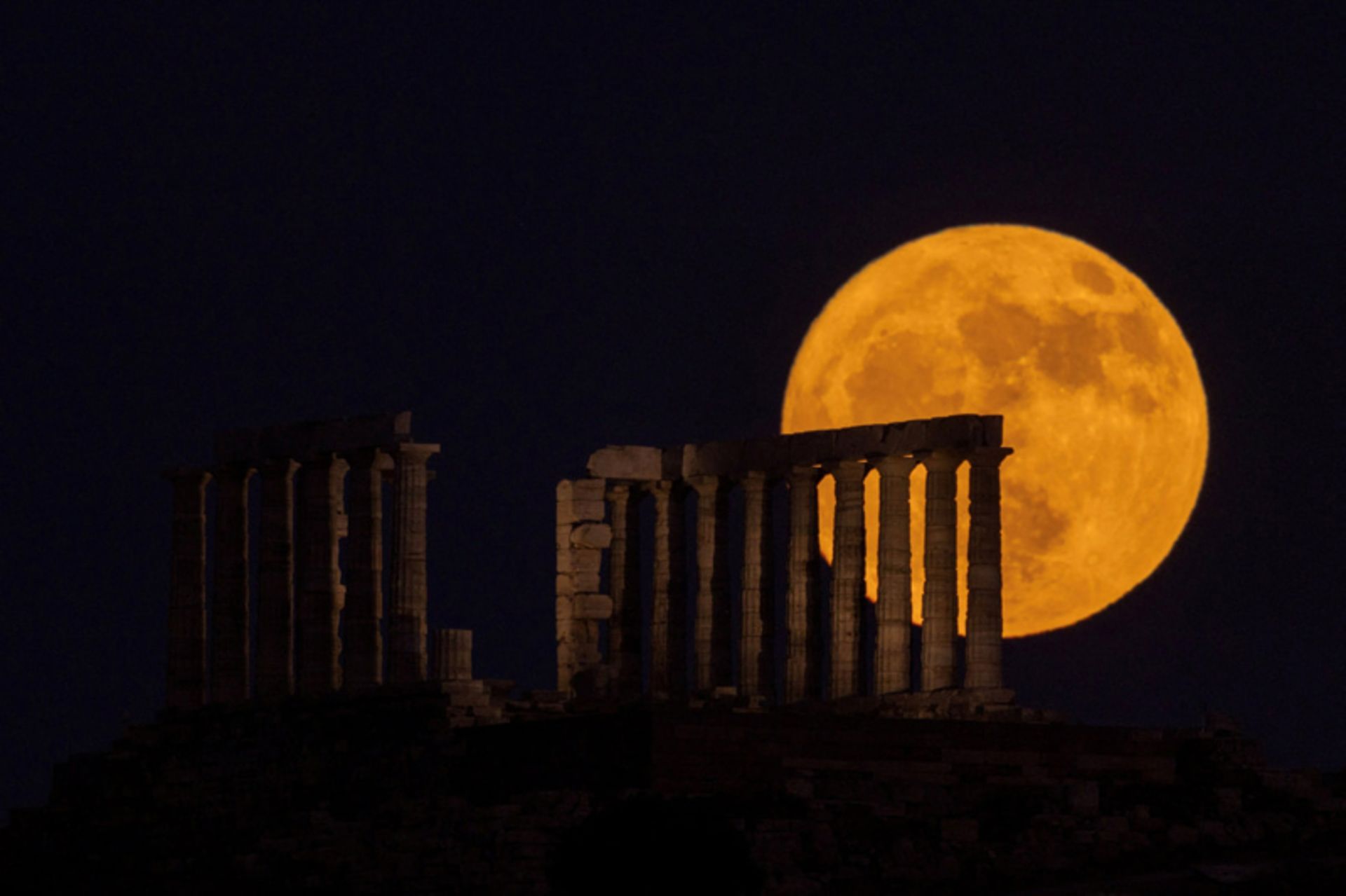 طلوع ماه توت فرنگی در پشت معبد پوزیدون (Poseidon) در کیپ سونیون (Cape Sounion)، یونان؛ عکاس: Alkis Konstantinidis 