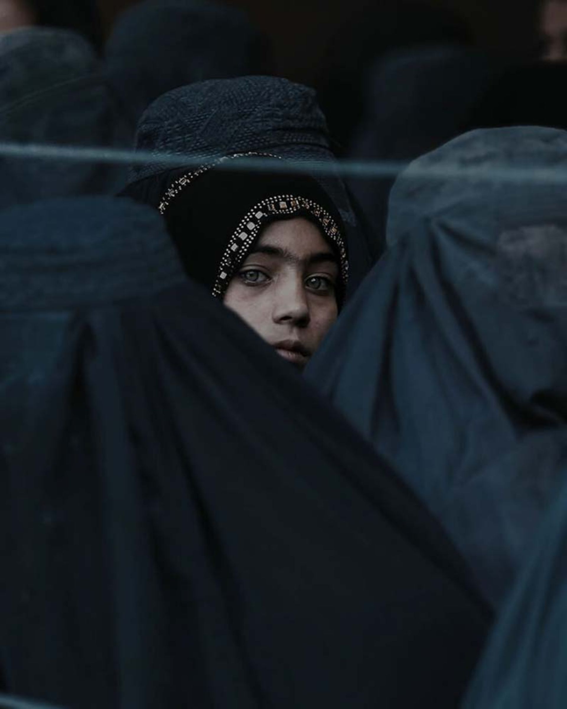 دختربچه‌ای در میان زنان محجبه