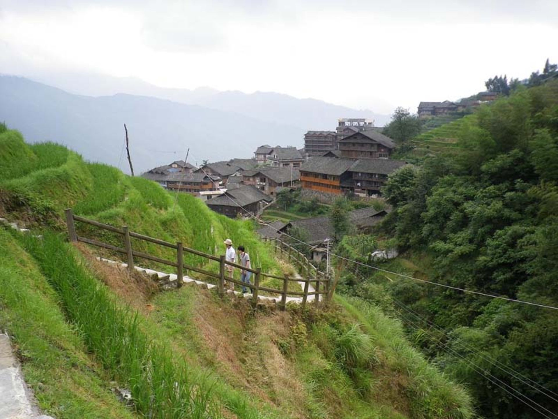 دو فرد در حال بالا رفتن  از پلکان چوبی در روستای پینگان 