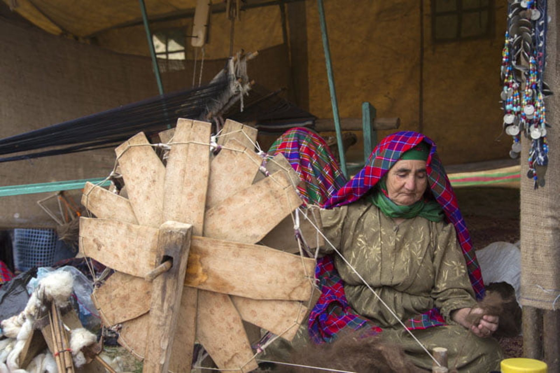 پیرزن روستایی در حال نخریسی در جشنواره شقایق‌ها در روستای حسین آباد کالپوش، منبع عکس: ویکی مدیا، عکاس: مصطفی معراجی  