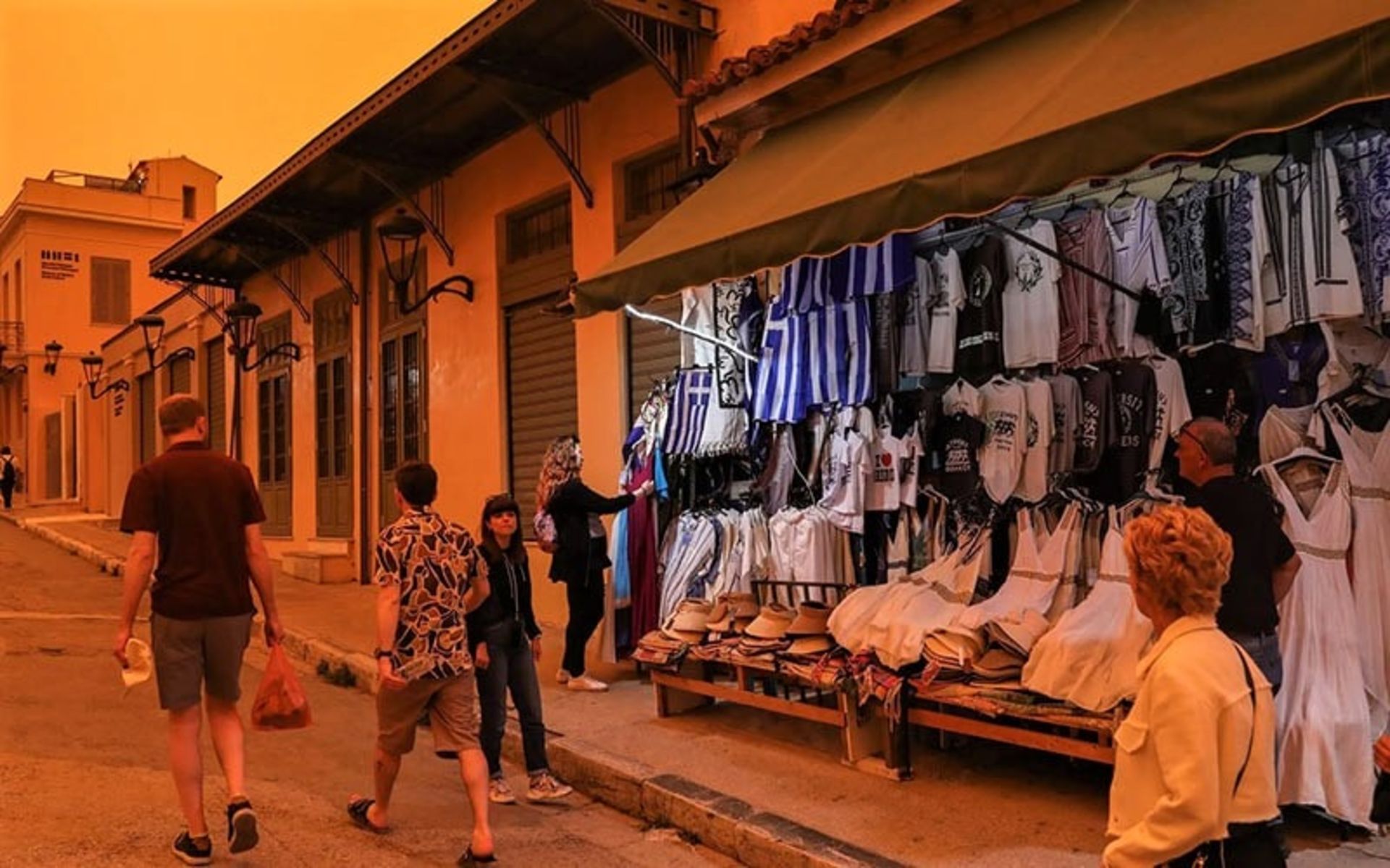 تردد مردم در خیابانی در هوای نارنجی رنگ آتن، منبع عکس: epaimages.com، عکاس: George Vitsaras
