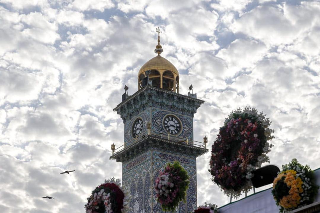 مناره ساعت حرم امام علی (ع) با حلقه گل از نمای پایین، منبع عکس: سایت حرم امام علی (ع)، عکاس: محمود الابراهیمی (mahmoud al ibrahimi)