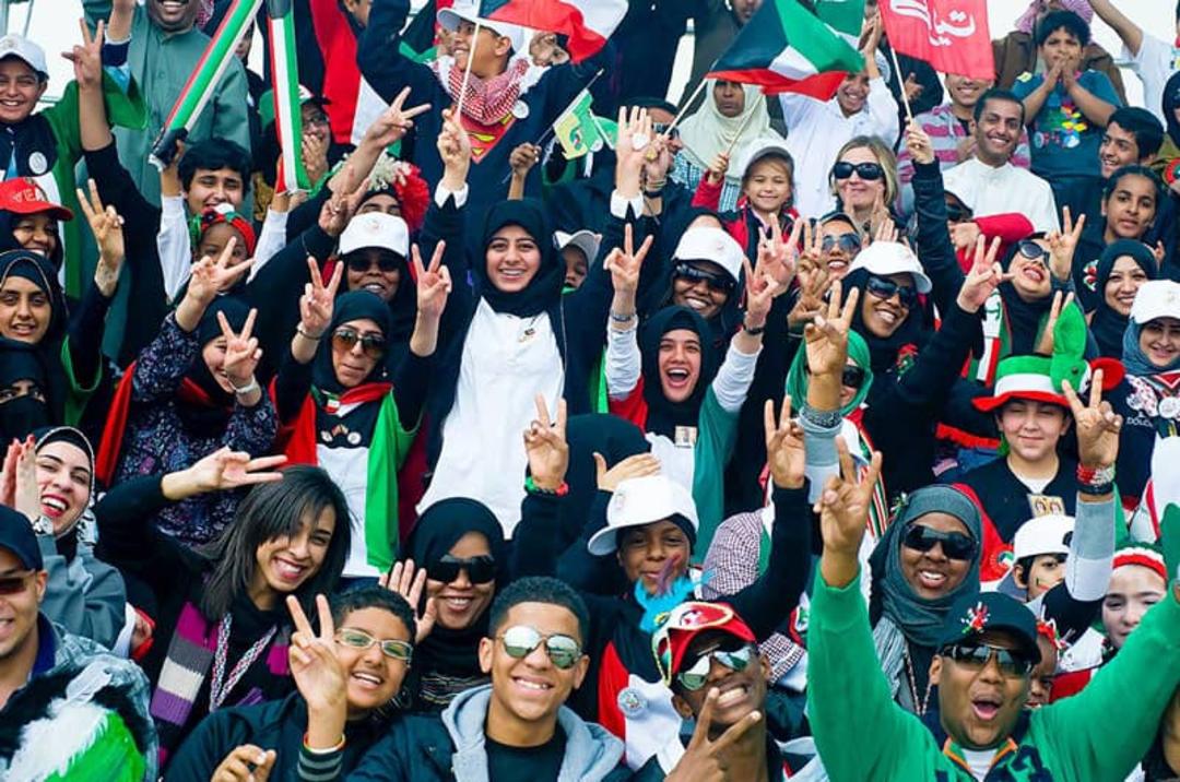 مردان و زنان کویتی در حال شادی و نشان دادن علامت پیروزی؛ منبع عکس: Nations online Project