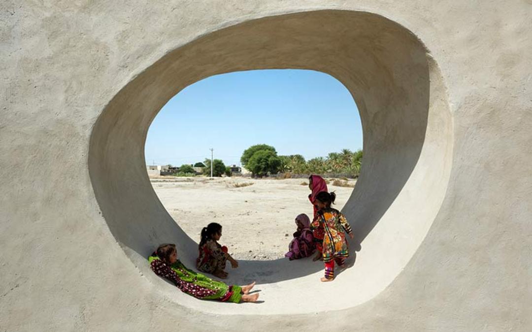 کودکان در حفره دیوار مدرسه جدگال چابهار، منبع عکس: archdaily.com، عکاس: نامشخص